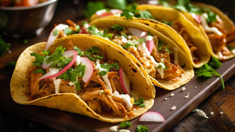 A platter of soft tacos on yellow corn tortillas