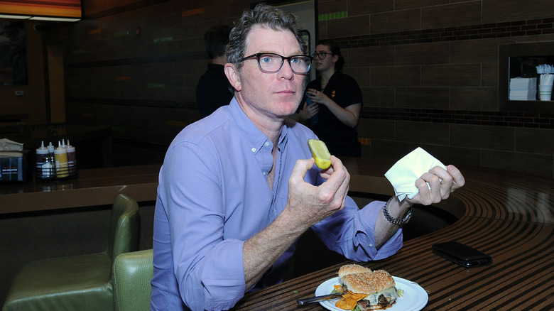 Bobby Flay with burger that includes barbecue chips