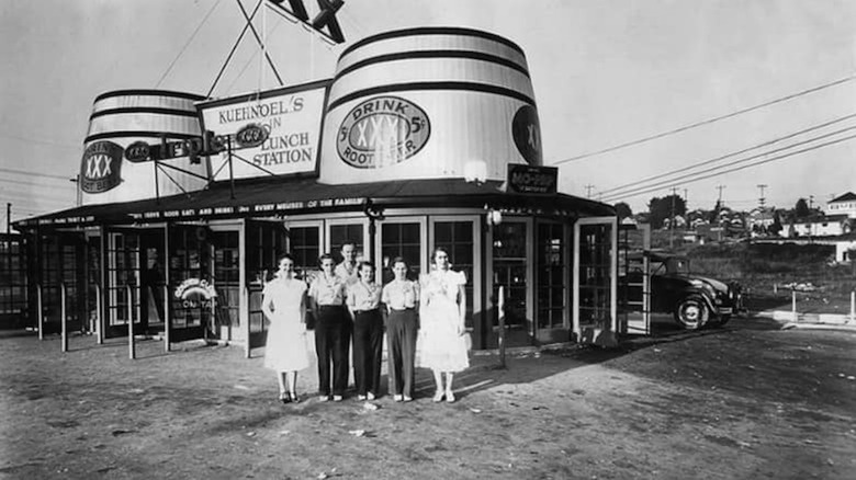 People standing in front of a Triple XXX Thirst Station