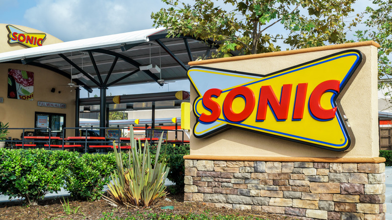 Outdoor seating and signage at a Sonic Burger restaurant