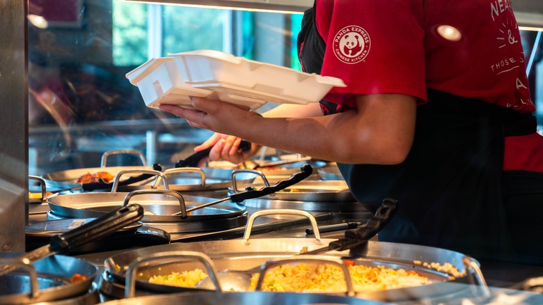 Panda Express employee scooping food into takeout container