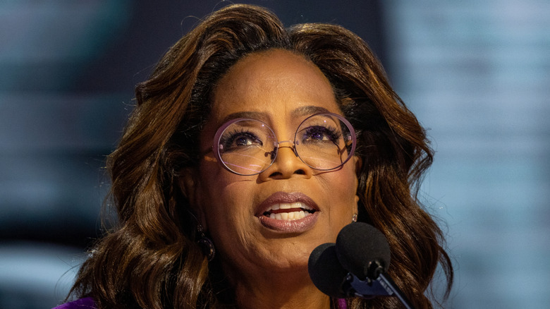 Close up of Oprah Winfrey behind a mic at a podium.