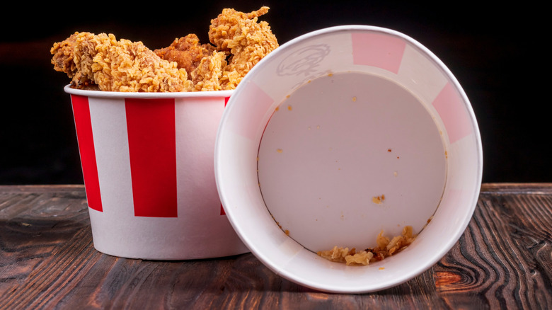 Two buckets of KFC chicken sitting on a table.