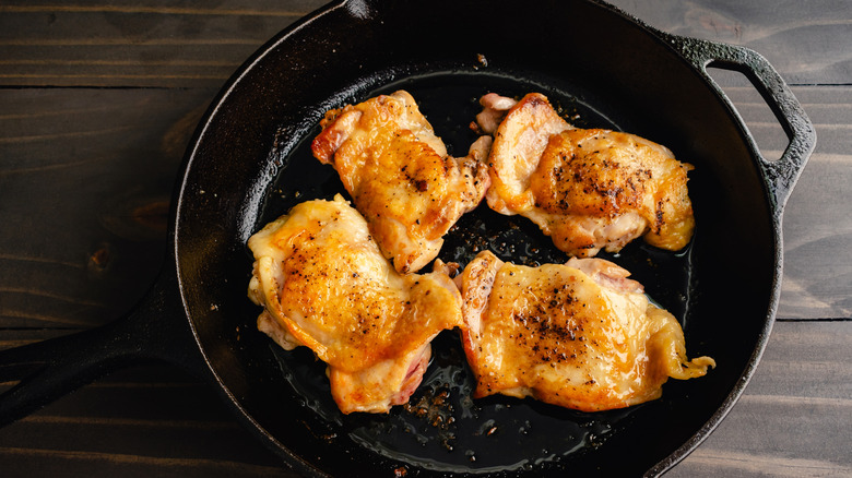 cast iron skillet with cooked chicken inside