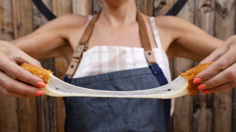 Woman stretching cheese stick