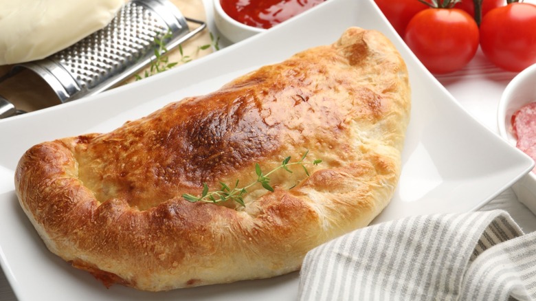 A calzone on a rectangular white plate.