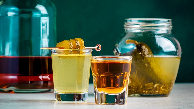 whiskey shot next to pickle juice in a glass