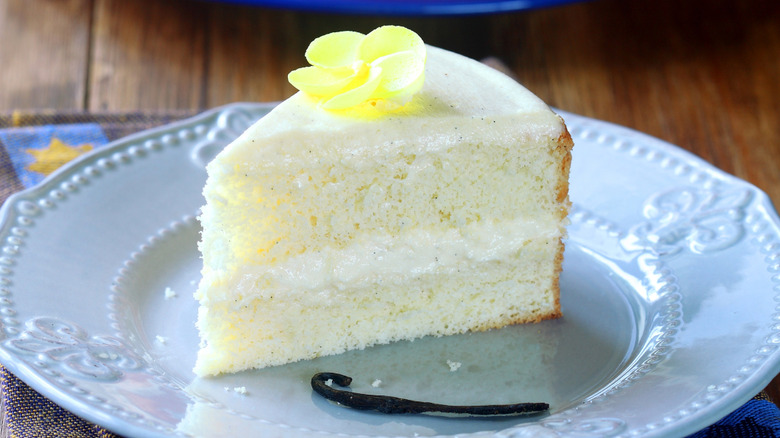 Slice of vanilla cake on a white plate.