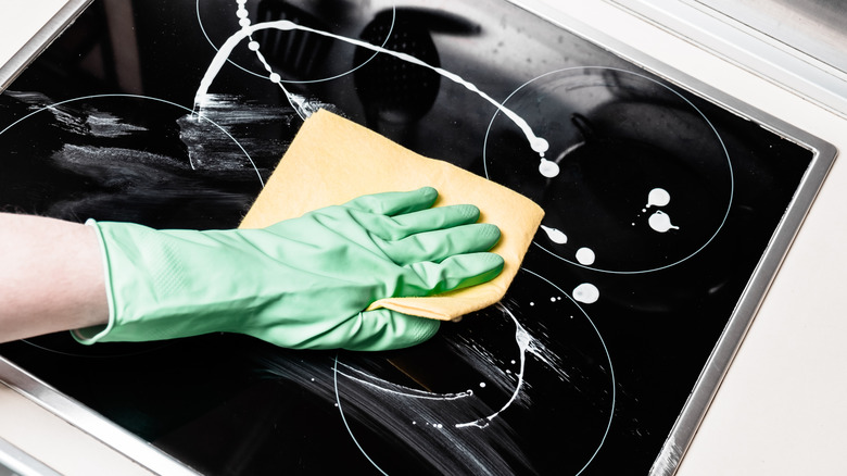 hand cleaning glass stovetop