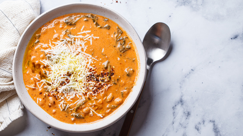 Creamy tomato and white bean soup with shredded cheese