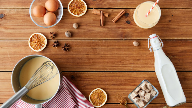 Eggnog ingredients laid out on a wooden sideboard