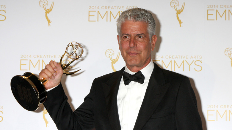 Anthony Bourdain holds an Emmy award