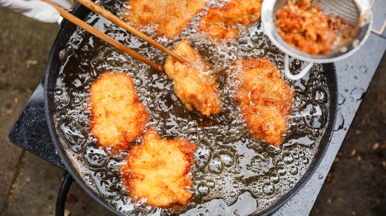 Chicken pieces frying in oil