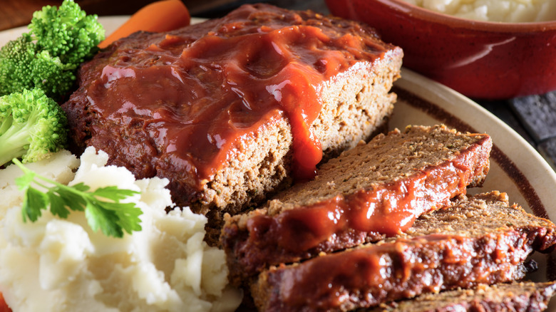 Meatloaf with mashed potatoes and broccoli served on a plate.