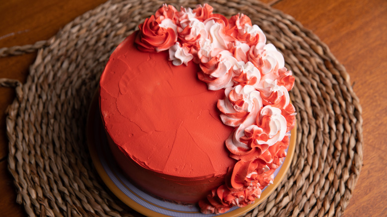 red buttercream frosted cake with red and white swirls