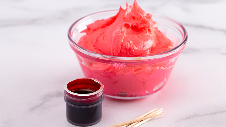 red gel food coloring and bowl of buttercream frosting