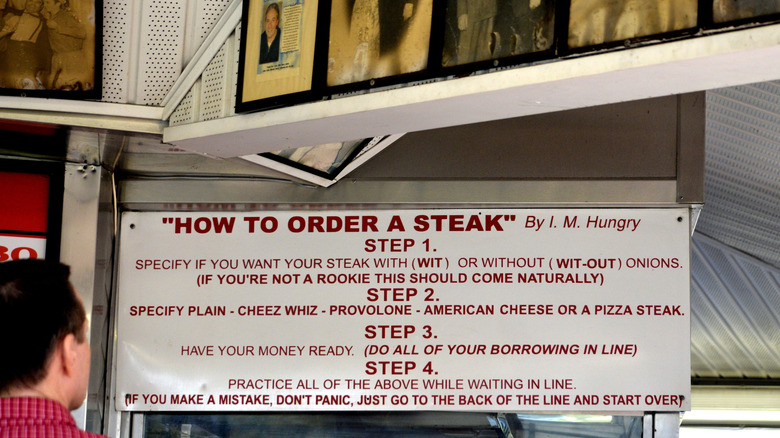 sign of humorous instructions for ordering cheesesteak