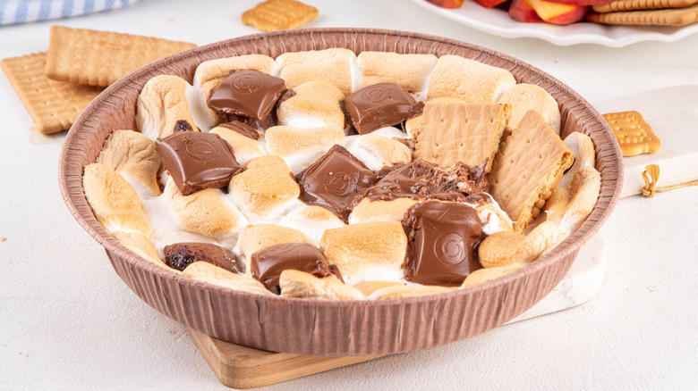 A brown tray of s'mores dip on a white surface