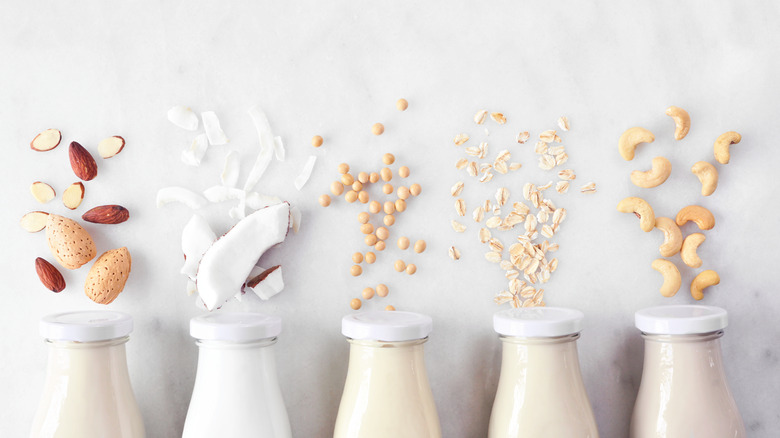 milk bottles lined up with nuts and coconut shreds on top of each