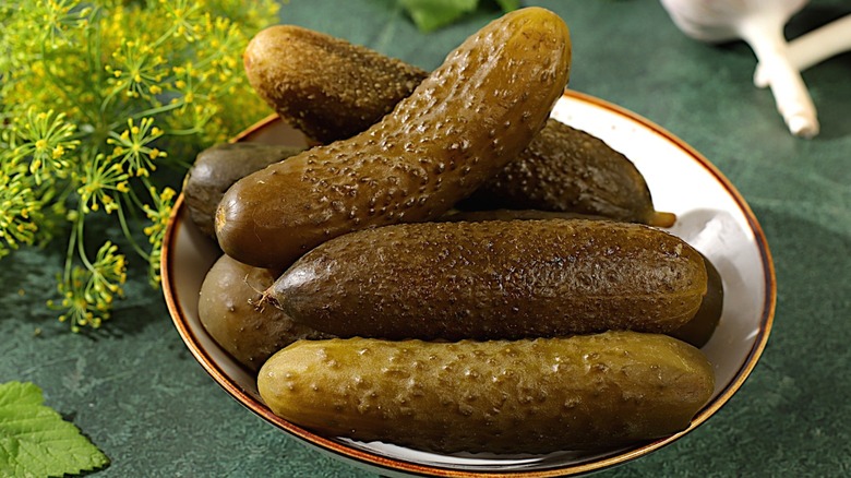 Several pickles in a ceramic bowl.