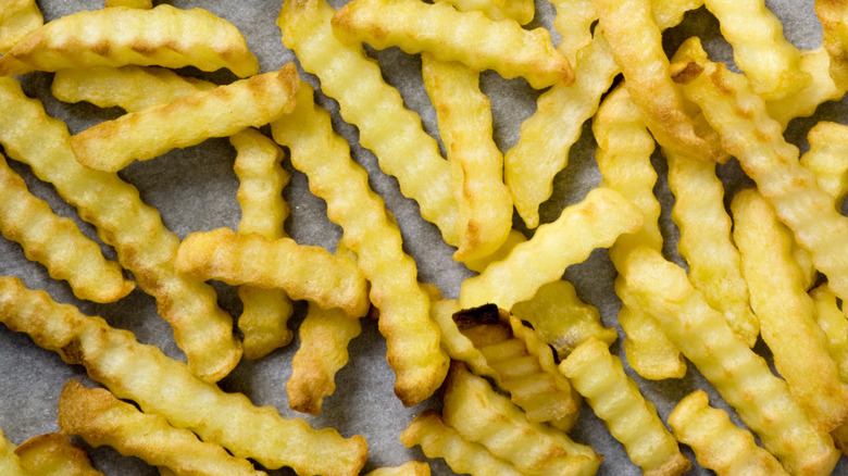 Frozen crinkle-cut french fries on a baking sheet