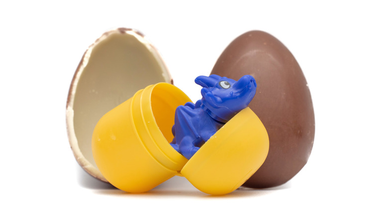 Kinder Surprise egg opened with an open capsule and a blue dragon figurine.