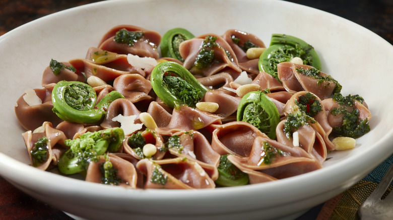 Cooked fiddlehead ferns with beet pasta and pesto