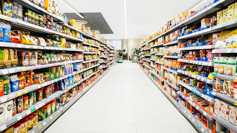 A long grocery store aisle with shelves packed with various products