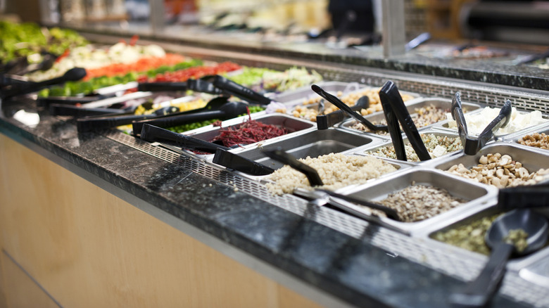 Grocery store salad bar with tongs