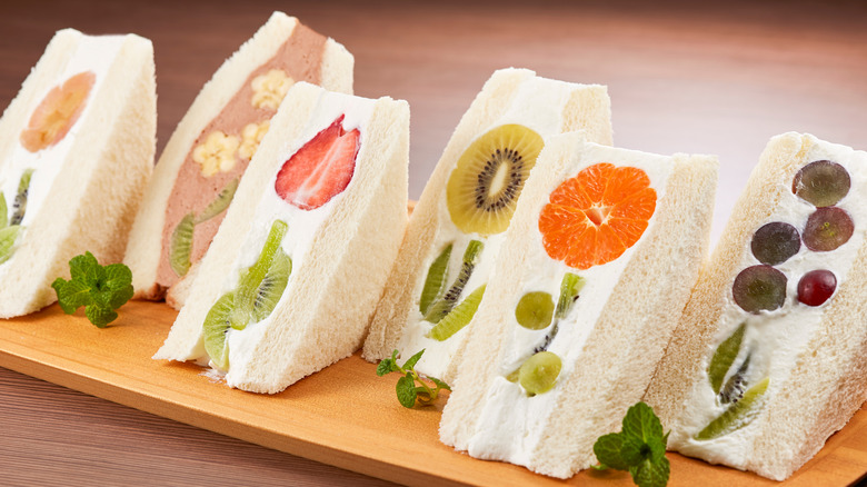 A tray of fruit sando sandwiches with flower designs.