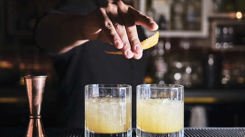 A bartender preparing two cocktails.