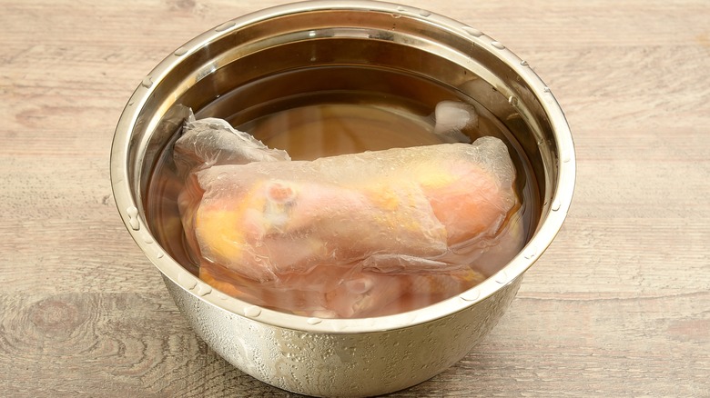 Packaged chicken thawing in water