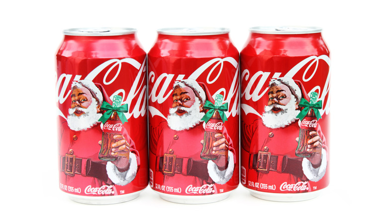 Cans of Coca-Cola are decorated with Santa in the Christmastime