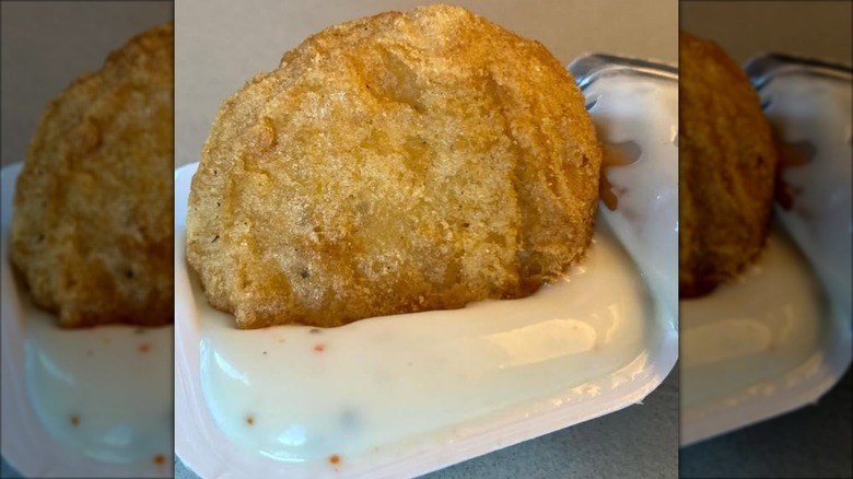 A McNugget being dipped in the scallop chowder sauce.