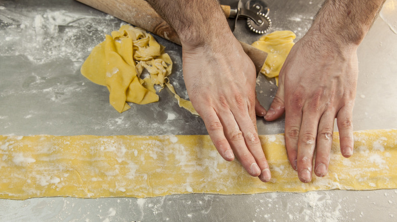 A person shaping homemade ravioli on a countertop