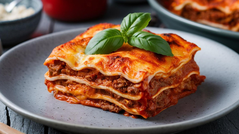 A serving of lasagne garnished with basil