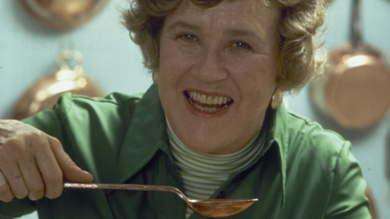 A closeup photo of Julia Child holding a large spoon