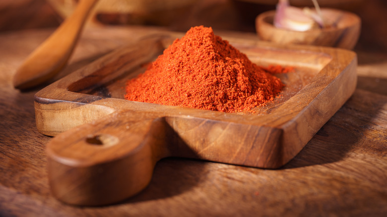 paprika powder in wooden bowl