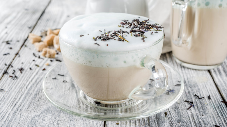 A tea latte sprinkled with dried herbs