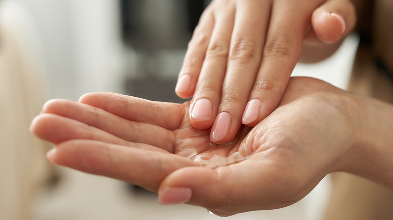 Two hands holding poured oil