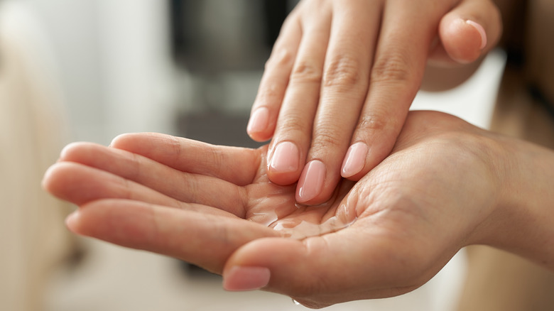 Two hands holding poured oil