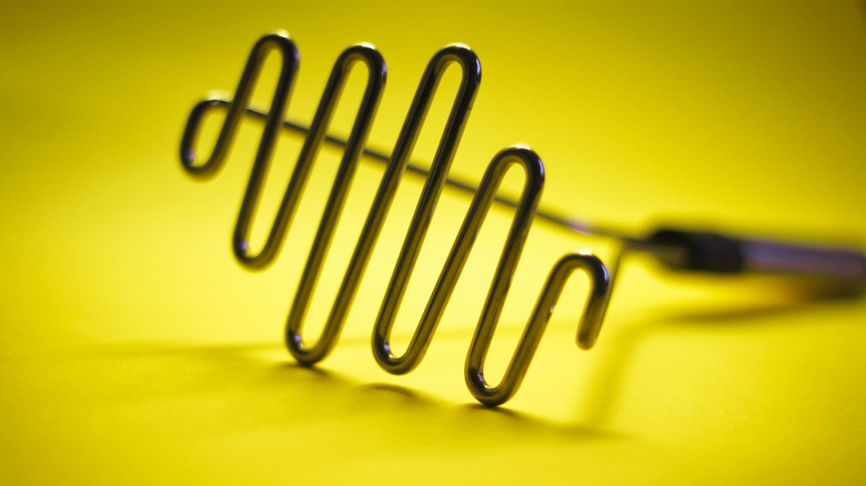 Potato masher on a yellow background