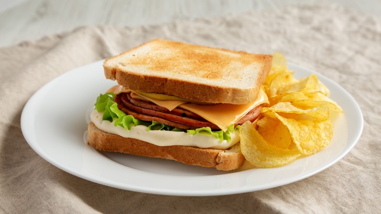 Fried bologna sandwich with chips on plate