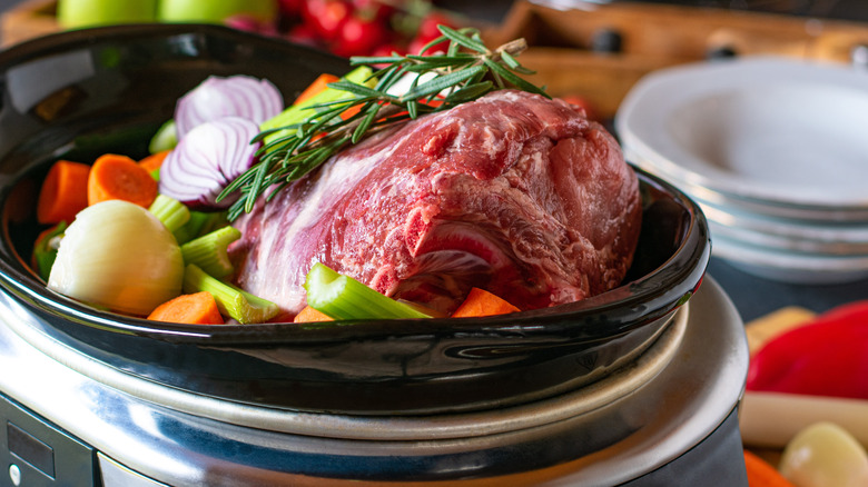 Raw pork and vegetables in slow cooker