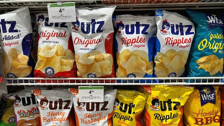 Supermarket shelves stocked with Utz and Wise brand potato chips.