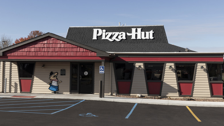 A Pizza Hut location with a character sign next to the front door