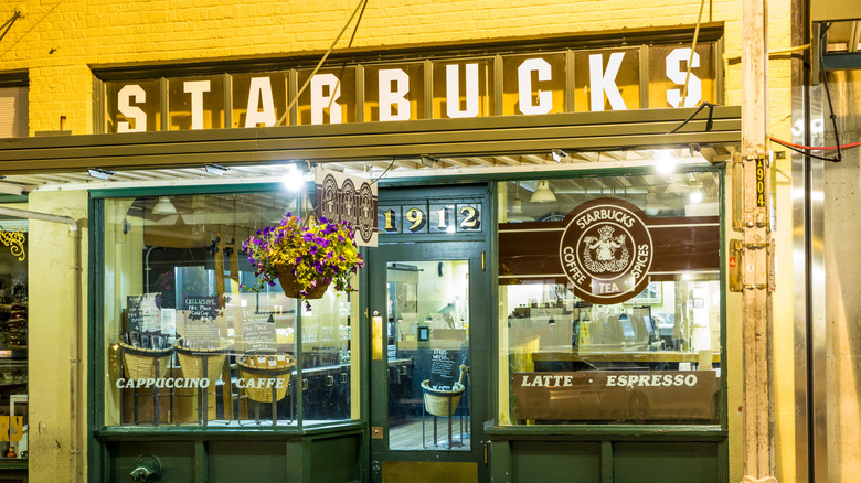 The exterior of the first Starbucks location in Seattle, Washington with its old logo on the window