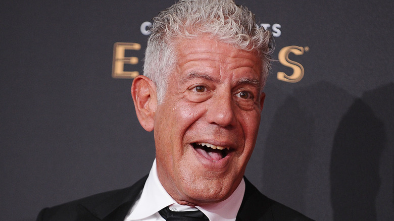 Anthony Bourdain open-mouthed smiling at an event