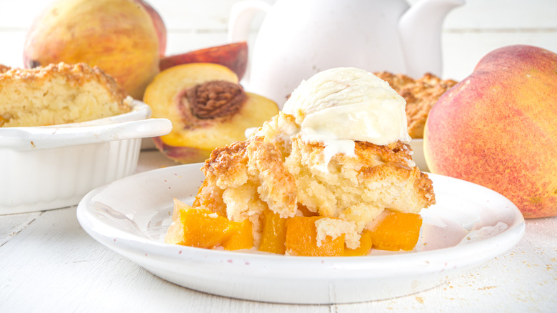 A plate of peach cobbler with a scoop of vanilla ice cream on top