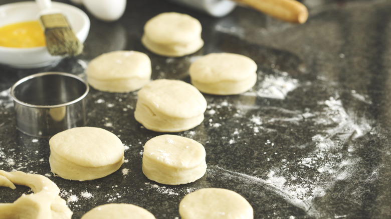 Unbaked biscuit dough on a black countertop